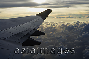 Asia Images Group - Airplane flying over clouds, view of wing through plane window
