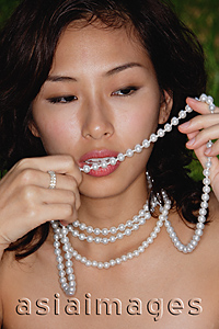 Asia Images Group - woman biting necklace, seductive