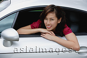 Asia Images Group - Woman sitting in car, hanging out driver side window, smiling at camera
