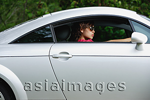 Asia Images Group - Woman driving sports car, wearing sunglasses