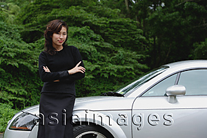 Asia Images Group - woman leaning on sports car, side of the road, smiling at camera