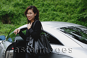 Asia Images Group - Woman getting into car, smiling at camera