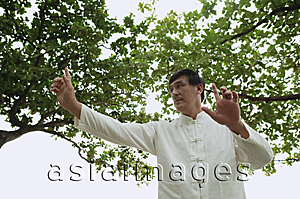 Asia Images Group - Man in park doing Tai Chi