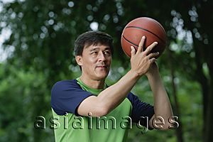 Asia Images Group - Man playing basketball in park, throwing ball