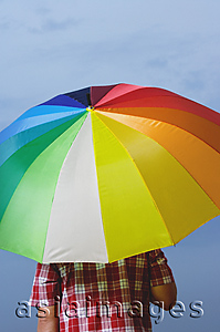 Asia Images Group - Man under rainbow umbrella, back to camera