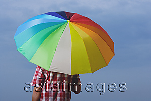 Asia Images Group - Man under rainbow umbrella, back to camera