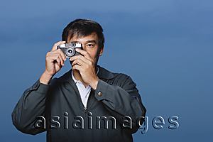Asia Images Group - Man taking picture with camera up to eye