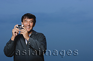 Asia Images Group - Man holding camera, smiling
