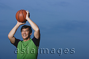 Asia Images Group - Man playing basketball, throwing ball, smiling