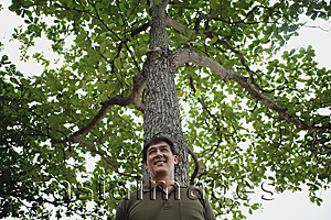 Asia Images Group - Man standing under tree in park