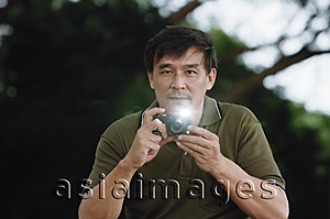 Asia Images Group - Man taking picture with flash going off