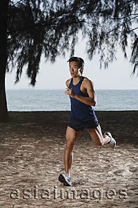 Asia Images Group - Man running along beach, workout