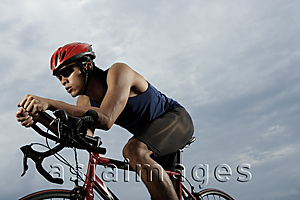 Asia Images Group - Man on bike racing, workout, wearing helmet