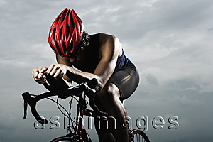 Asia Images Group - Man on bike, pedaling, racing, looking down