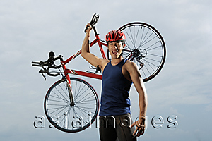 Asia Images Group - Man raising bike over shoulders, happy, finished race, looking at camera