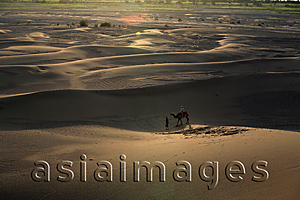 Asia Images Group - A tourist riding on camel back in the dune, Shanshan, Turpan, Xinjiang