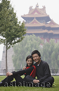 Asia Images Group - A couple smile at the camera as they sit in front of The Forbidden City, Beijing