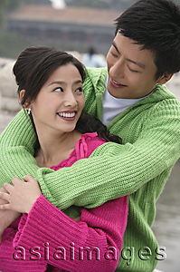 Asia Images Group - A couple smile as they have their arms around each other