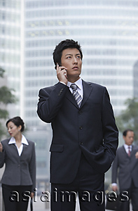 Asia Images Group - A businessman uses his cellphone