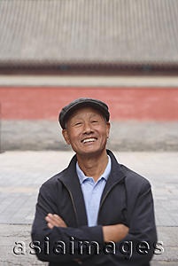 Asia Images Group - An old man crosses his arms and smiles at the camera
