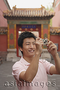 Asia Images Group - A man smiles as he takes photos