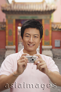 Asia Images Group - A man looks at the camera and takes a photo