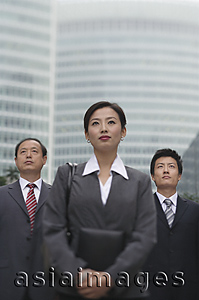 Asia Images Group - Three business professionals stand in front of a skyscraper