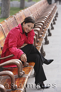 Asia Images Group - A woman smiles at the camera as she sits down