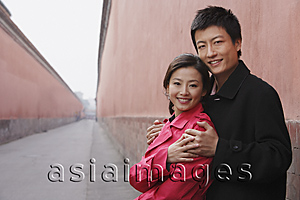 Asia Images Group - A couple have their arms around each other as they look at the camera
