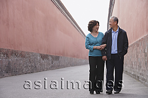Asia Images Group - A man and woman link arms as they walk together