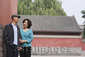 Asia Images Group - A man and woman link arms as they walk together