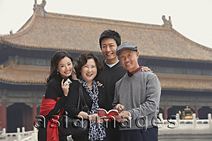Asia Images Group - A family look at the camera as they pose in front of The Forbidden City, Beijing