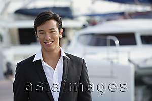 Asia Images Group - Man in front of yacht, smiling at camera