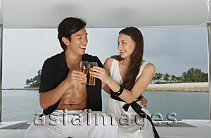 Asia Images Group - Couple on yacht, toasting with glasses