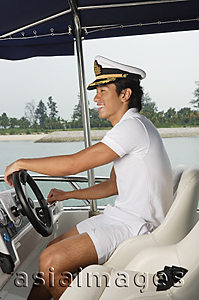 Asia Images Group - Man steering yacht
