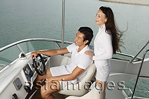 Asia Images Group - Young couple on yacht, looking into distance