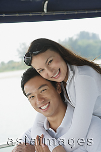 Asia Images Group - Young couple on yacht, smiling at camera
