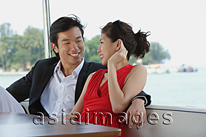 Asia Images Group - Young couple on yacht, looking at each other