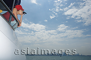 Asia Images Group - Young woman with binoculars on yacht, looking into distance
