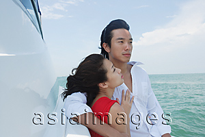 Asia Images Group - Young couple on yacht with arms around each other