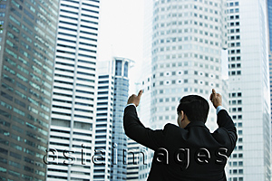 Asia Images Group - Businessman gives thumbs up, in front of skyscrapers