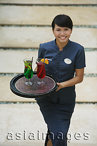 Asia Images Group - Balinese waitress carrying cocktails