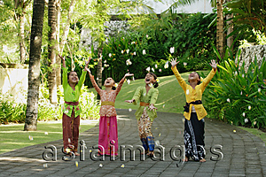 Asia Images Group - Balinese girls laughing and throwing flowers