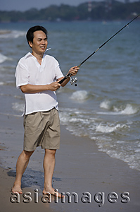 Asia Images Group - Man fishing at the beach