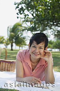 Asia Images Group - Woman lying in the park, having a picnic