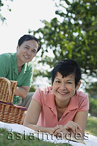 Asia Images Group - Mature couple having a picnic in the park, smiling at camera