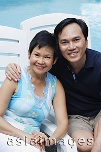 Asia Images Group - Mature couple by the pool smiling at camera