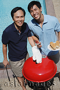 Asia Images Group - Father and son enjoying barbeque