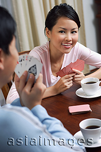 Asia Images Group - Young couple playing cards