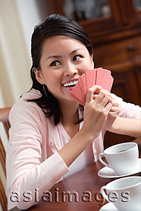 Asia Images Group - Young woman playing cards